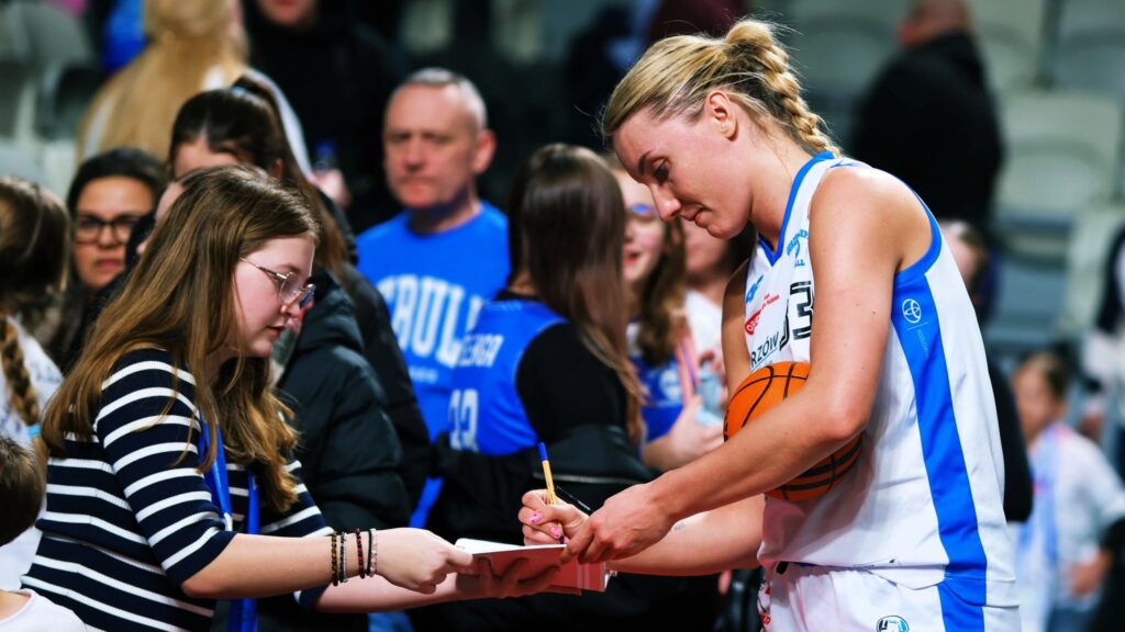 Kobieta w sportowym stroju rozdająca autografy