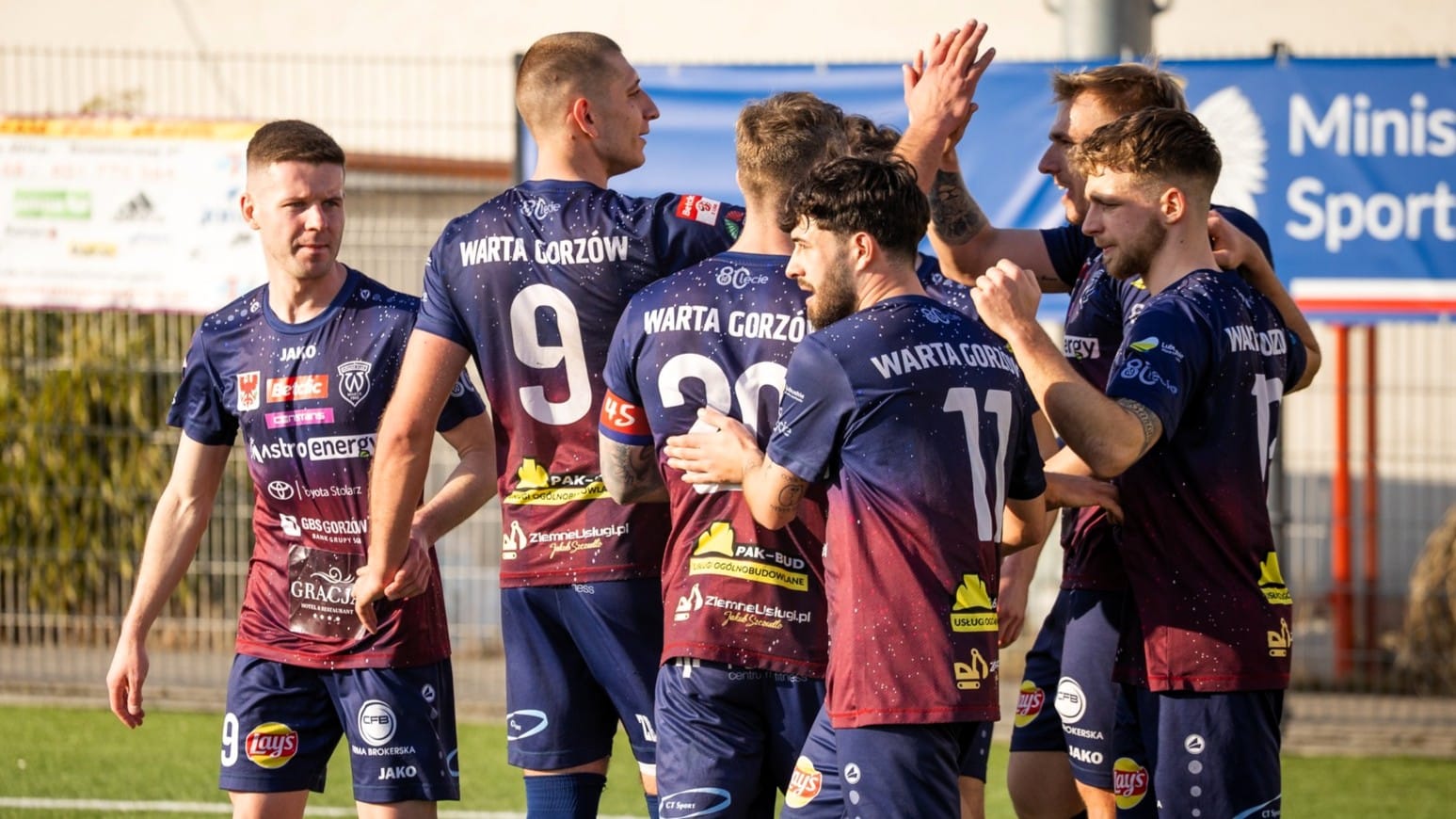 Grupa cieszących się mężczyzn w sportowych strojach  Piłkarski weekend Warta podejmie Lechię