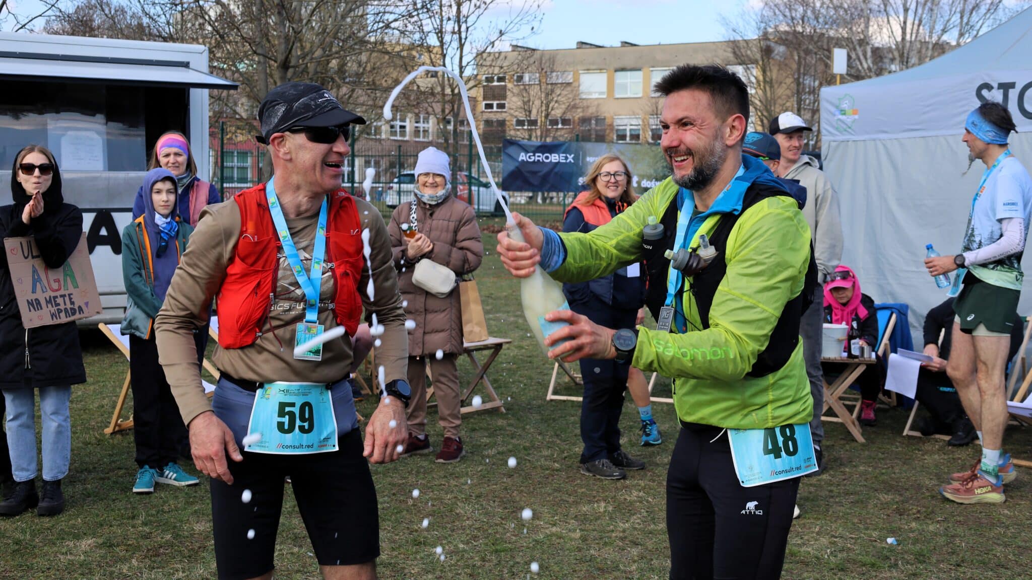 Dwaj mężczyźni w sportowych strojach otwierają szampana  103 kilometry w niespełna 9 godzin Tak się biega ultramaratony