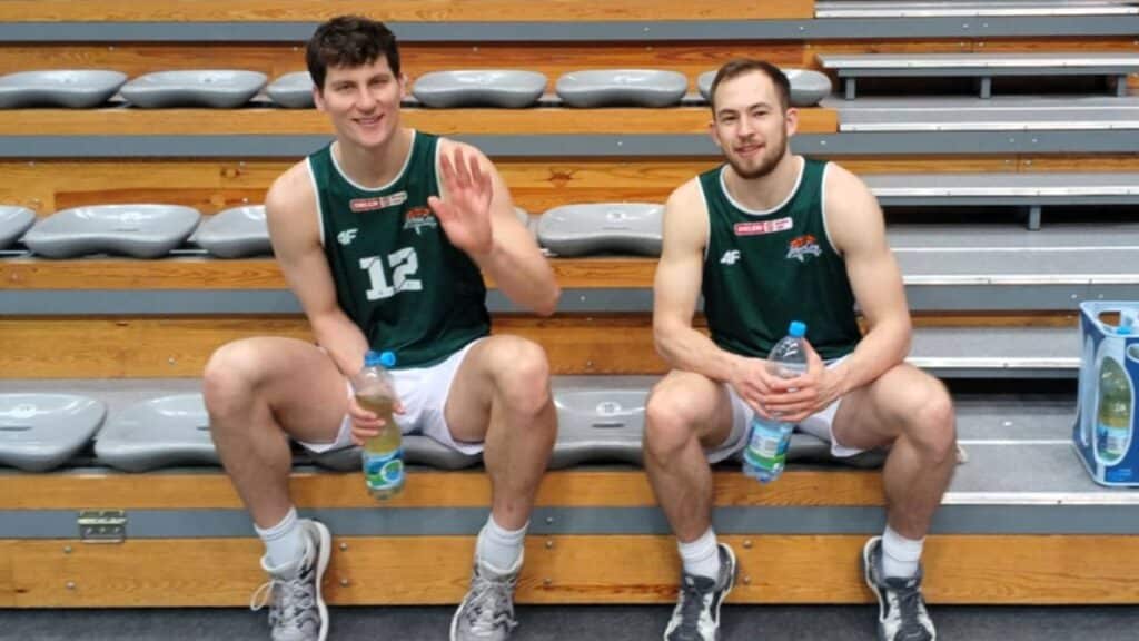 Dwaj uśmiechnięci mężczyźni w sportowych strojach