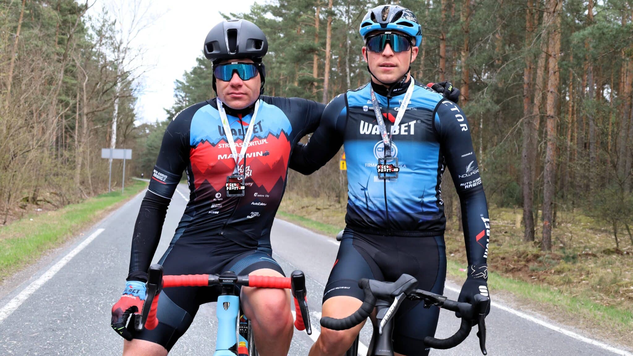 Dwaj mężczyźni w sportowych strojach i kaskach  Będzie piekło Ale kolarze to kochają